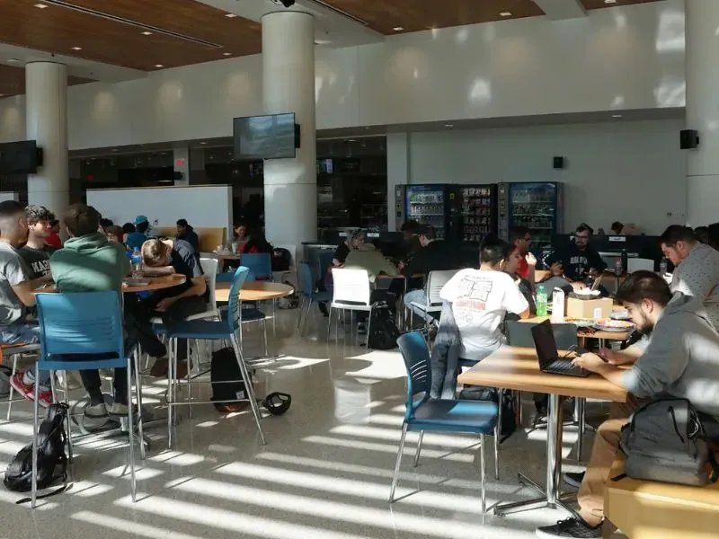 Students sitting at tables inside the cafeteria